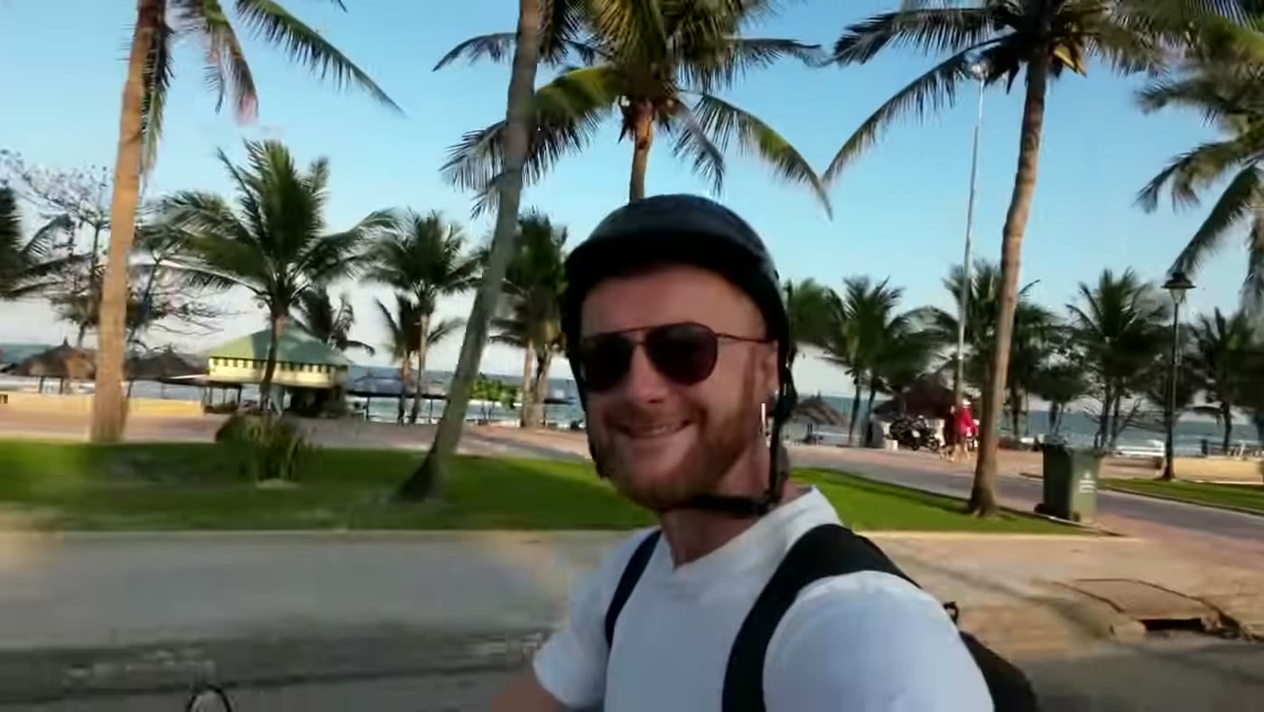 Marcin mit Helm und Sonnenbrille auf dem Roller an der Strandstraße von Da Nang