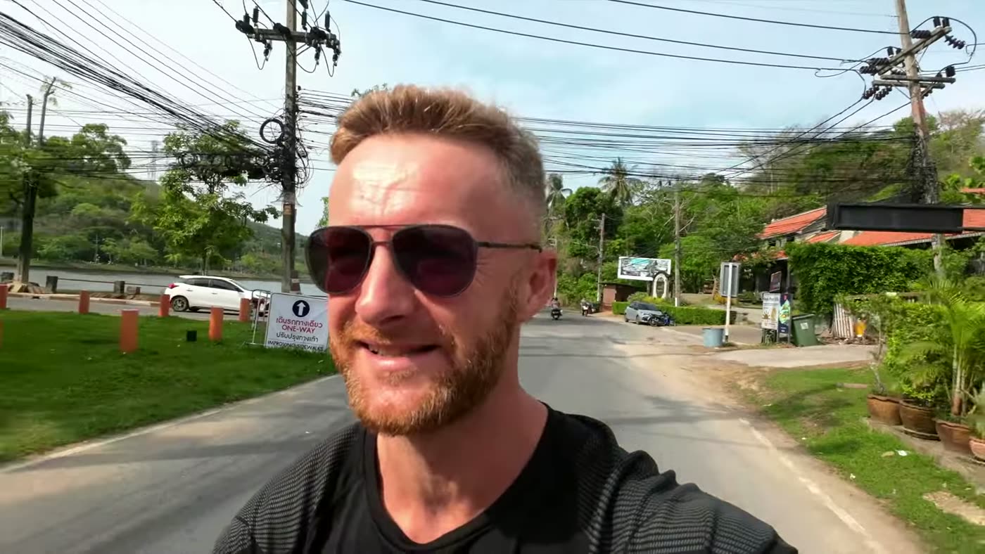Marcin mit Sonnenbrille auf seinem 160er-Roller auf einer Straße in Phuket