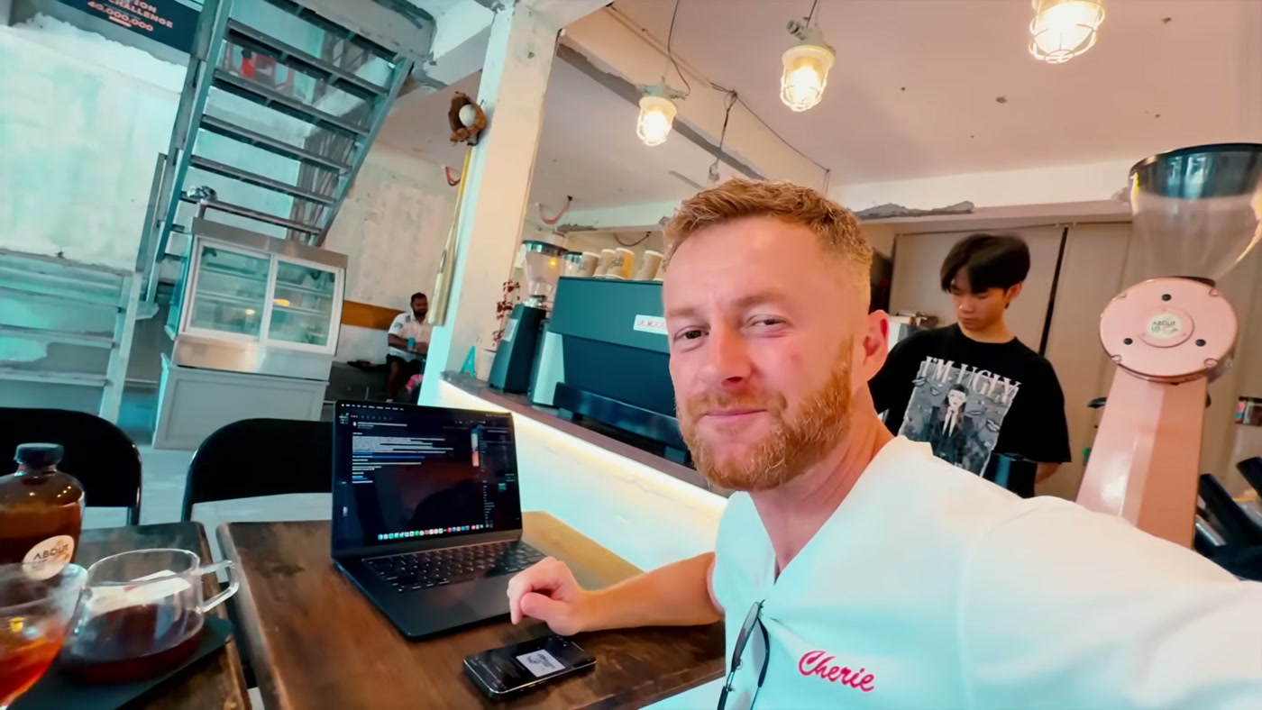 Marcin mit Laptop und Handy in einem Café in Da Nang