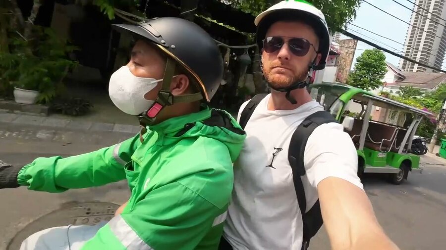 Marcin mit Helm auf dem Rücksitz eines Grab-Rollers in Da Nang